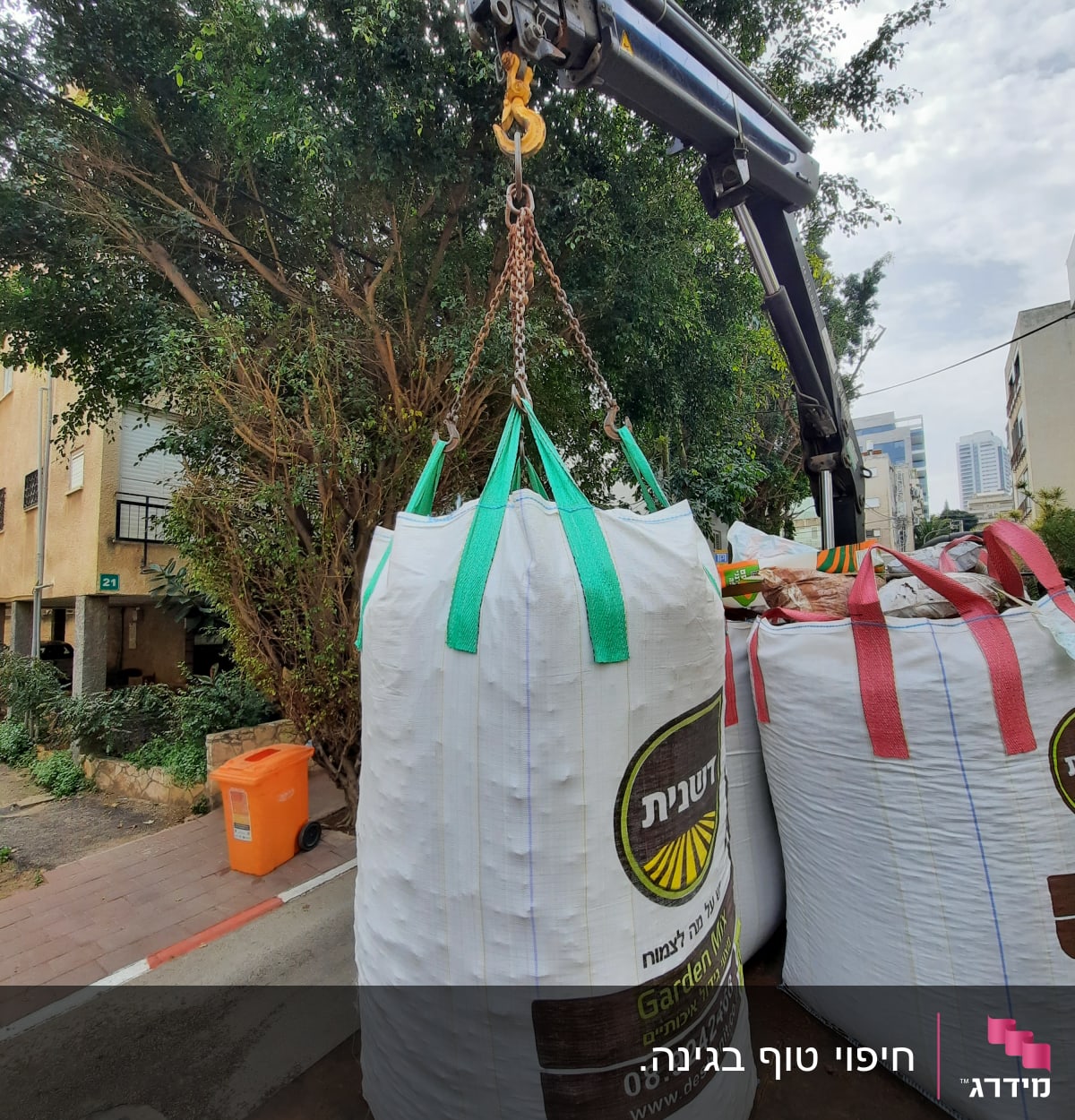 שק גדול עם חומרי גינון תלוי על מנוף